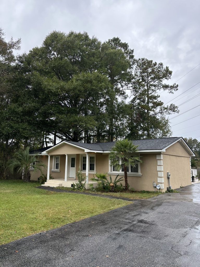 Tan single-story home with a covered front porch and new shingle roof in Myrtle Beach, SC