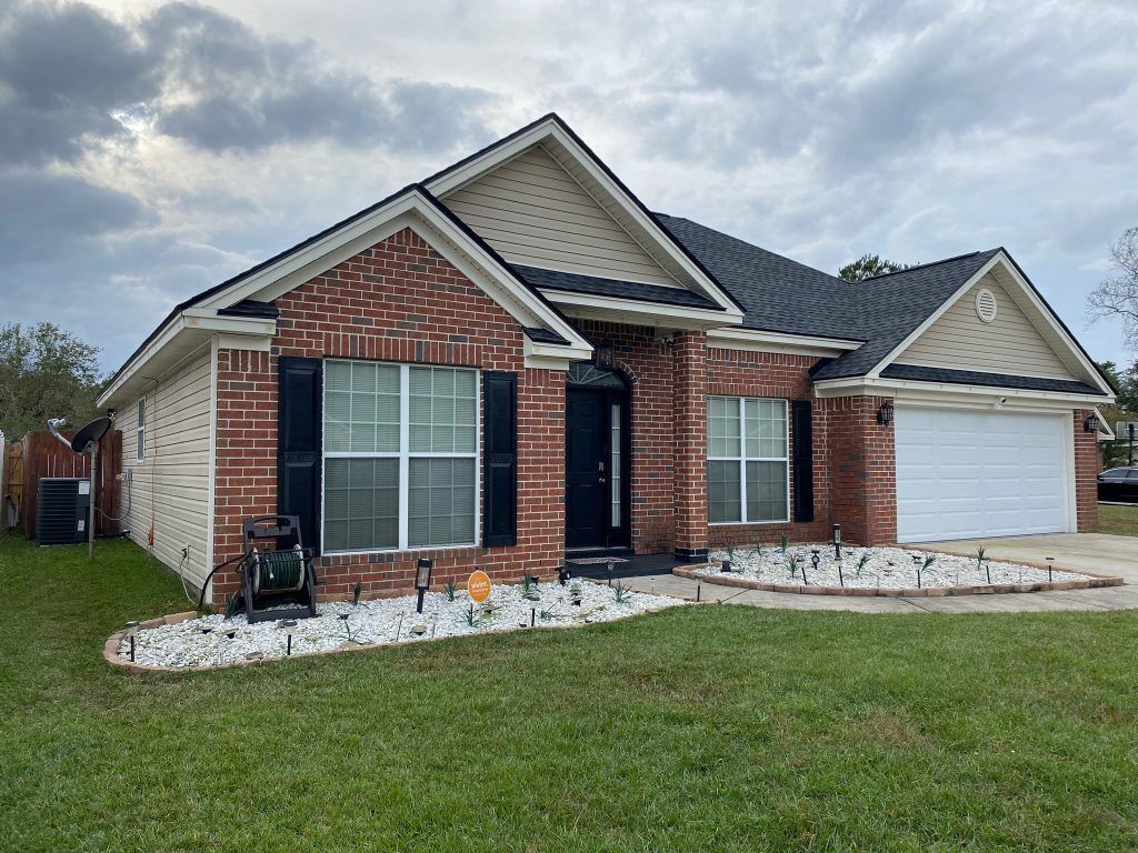 item_7183e411-648c-4a1d-85bf-b18eb9cf9a0c Single-story tan home with a two-car garage and freshly installed shingle roof in Savannah, GA