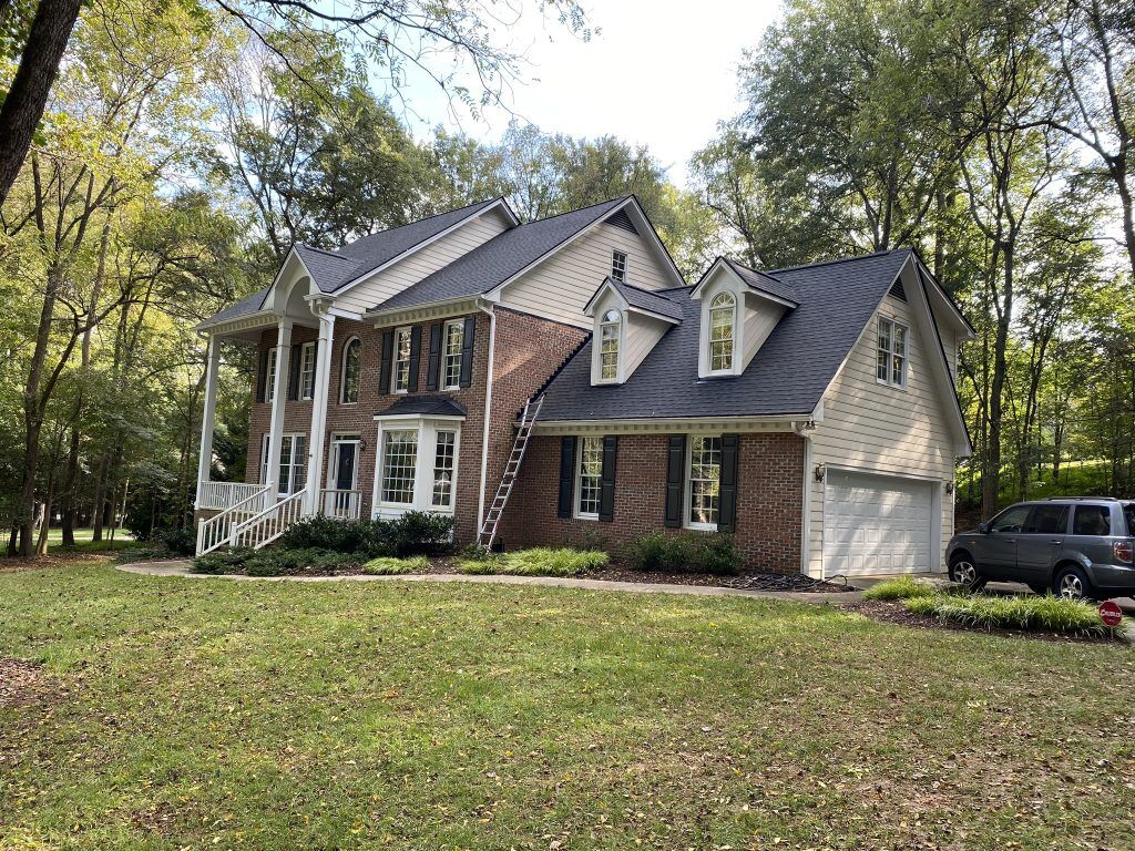 item_9621d54e-0827-4571-b199-b73d5e9f8660 Two-story home with white trim and a freshly installed dark shingle roof in Raleigh, NC