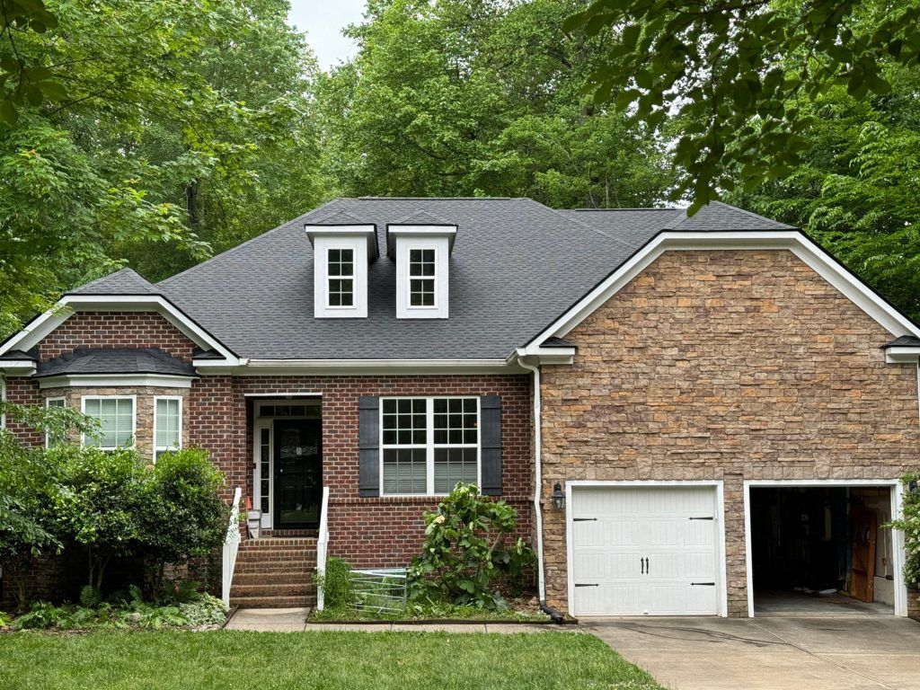 item_e9821f26-b8f5-467a-b855-c30ea9932d9d Single-story brick and stone-accent home with dormer windows and a new shingle roof in Raleigh, NC