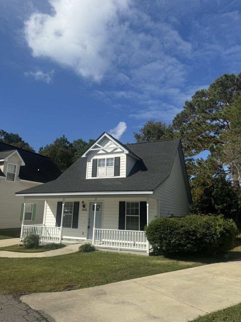 Gray-tan two-story home with dormer windows and a newly installed shingle roof in Myrtle Beach, SC